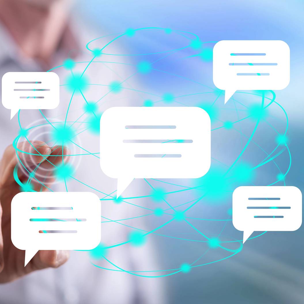 Man touching a global communication concept A person points at floating chat bubbles connected by a digital network, representing online communication or messaging technology.